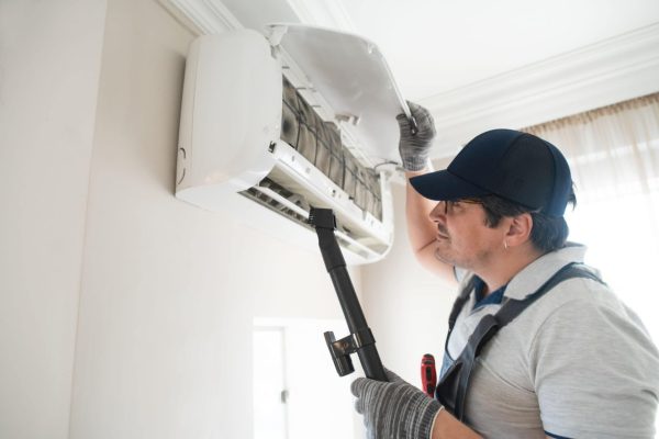 Technician clearing air conditioner-min