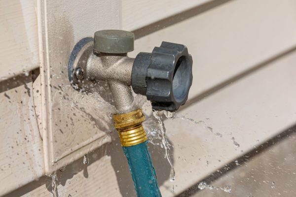 Water leaking from garden hose on outdoor spigot. Water wast-min